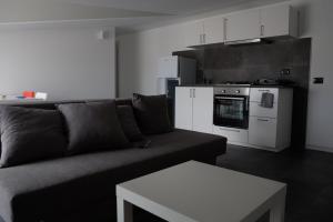 ein Wohnzimmer mit einem Sofa und einer Küche in der Unterkunft A due passi da una spiaggia meravigliosa in Crotone