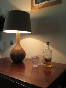 a bottle of whiskey and two glasses on a table at Balvraid Lodge B&B in Inverness
