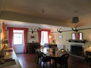 a living room with a table and chairs and a fireplace at Balvraid Lodge B&B in Inverness