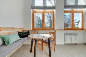 ソポトにあるApartamenty Joasiaのテーブル、ソファ、窓が備わる客室です。