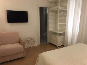 a bedroom with a couch and a tv and a closet at Affreschi a San Pietro in Rome