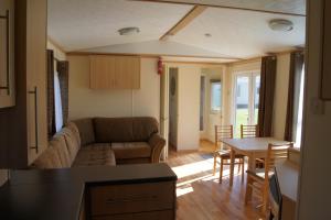 a living room with a couch and a table at Landbouwlust Chalets in Serooskerke