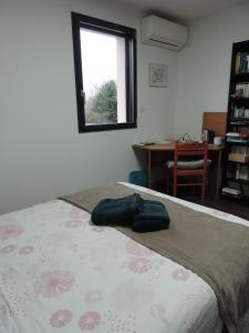 1 dormitorio con 1 cama con 2 toallas en Jolie maison d’architecte en Chambray-lès-Tours