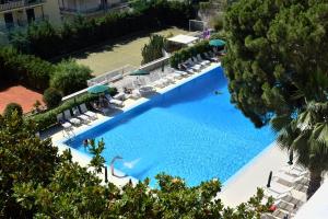 una vista aérea de una gran piscina con sillas y sombrillas en Residence Oliveto en Ceriale