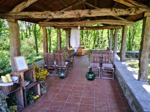 een patio met stoelen, tafels en bomen bij Casa Do Cribeiro in Ponteareas