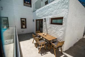 a patio with a wooden table and chairs next to a building at Las Nieves Blue in Agaete