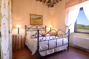 a bedroom with a black bed and a window at villa San Fabiano with heated pool in Monteroni dʼArbia