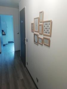 einen Flur mit einer weißen Wand mit Bildern darauf in der Unterkunft Disneyland/Paris 1 a10 personnes climatisee in Pontault-Combault