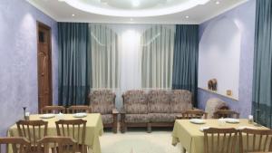 a dining room with two tables and a couch at Sunny Hotel Batumi in Makhinjauri