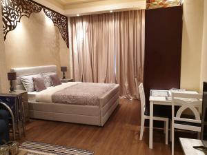 1 dormitorio con cama, mesa y escritorio en Haven Studio Apartments, en Ras al Khaimah