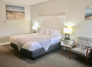 a bedroom with a large bed and a chair at Empire Lakeshore Inn in Empire