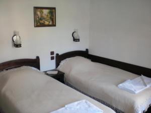 a bedroom with two beds and a picture on the wall at Къща за гости Старият Град Златоград in Zlatograd