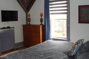 1 dormitorio con 1 cama, vestidor y ventana en Ô Bois Dormant B&B en Magog-Orford