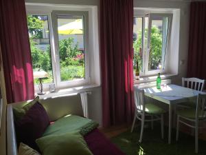 ein Esszimmer mit einem Tisch und 2 Fenstern in der Unterkunft Ferienwohnung Sonja am Weinberg in Radebeul