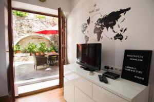 a living room with a tv and a world map on the wall at Studio Terrace Borgoforte in Trogir
