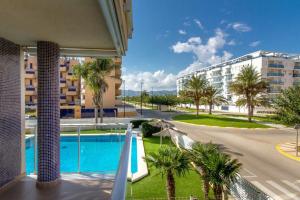 a view of a resort with a pool and palm trees at Estudio en primera linea de playa in Daimuz