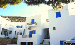 a white apartment building with blue windows at LARINAKI'S STUDIO No2 in Amorgos