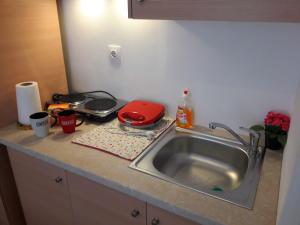a kitchen counter with a sink and a red appliance at LARINAKI'S STUDIO No2 in Amorgos +11 photos