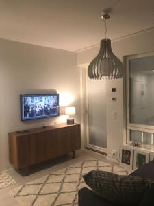 a living room with a flat screen tv on a wall at PikkuParlamentti in Pori