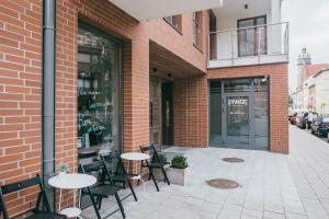 a brick building with tables and chairs on a sidewalk at Harmonica - Luxury Apartment - A/C in Krakow