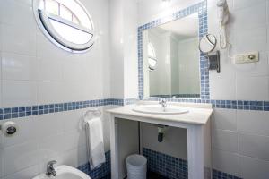 a bathroom with a sink, toilet and mirror at Elcano in Málaga