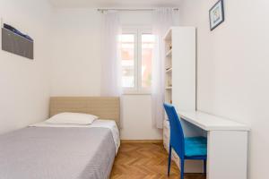 ドゥブロヴニクにあるGuesthouse Tonkoのベッドルーム1室(ベッド1台、デスク、青い椅子付)