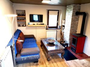 a living room with a couch and a table and a tv at Predel House in Log pod Mangartom