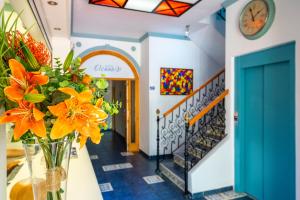 um corredor com um vaso de flores de laranja e escadas em Elcano em Málaga