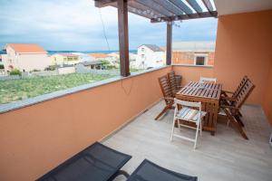 ein Balkon mit Tisch und Stühlen und einem Fenster in der Unterkunft Apartman Matej with pool Povljana in Povljana