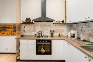 uma cozinha com armários brancos e um forno com placa de fogão em RIS Dalma Collection Yerevan em Yerevan