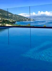 a large swimming pool with a view of the ocean at Villa Renata Gold in Barbati