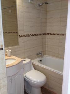 a bathroom with a toilet and a sink and a tub at Beachfront Apartment Reñaca Chile in Viña del Mar
