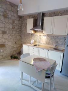 a kitchen with white cabinets and a table and chairs at Apartment Iris in Drasnice