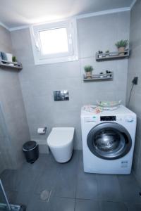 uma casa de banho com uma máquina de lavar roupa e um WC em A & V Luxury apartment - Kalamata em Kalamata