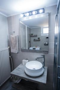uma casa de banho com um lavatório e um espelho em A & V Luxury apartment - Kalamata em Kalamata