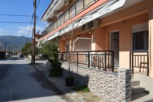 a building with a balcony on the side of a street at Lafazanis rooms in Nea Vrasna