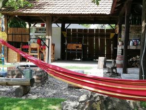 a red hammock in front of a building at Bóbita Apartmanház in Szilvásvárad