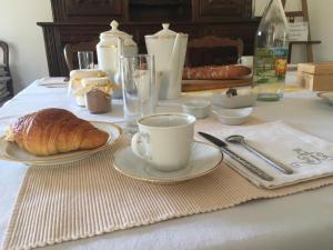 a table with a cup of coffee and a croissant at La Huberdière in Fondettes