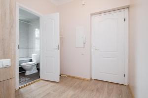 a bathroom with a toilet and a white door at Suurkarja Apartment in Tallinn +22 photos