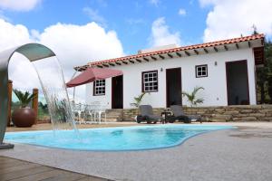 a pool with a water fountain in front of a house at Biz & Biu Pousada Lavras Novas in Lavras Novas