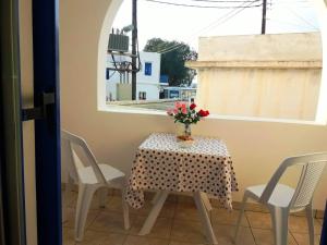 a table and chairs with a vase of flowers on it at LARINΑKI'S STUDIO No1 in Amorgos +15 photos