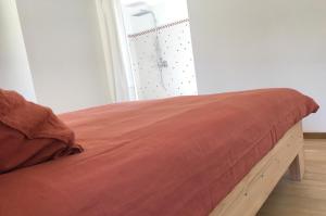 a bed with a wooden frame in a room at Chambre à la ferme in Précy-le-Sec