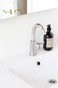 a bathroom sink with a bottle of soap next to it at Vibæk in Sønderborg