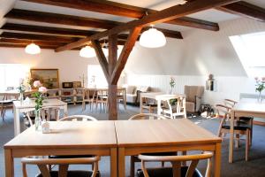 a dining room with tables and chairs and lights at Rønhave in Sønderborg