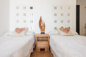 two beds sitting next to each other in a room at Nyumba ya Sun in Cala Tarida