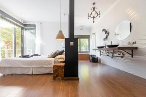 a bedroom with a bed and a desk and mirror at Nyumba ya Sun in Cala Tarida