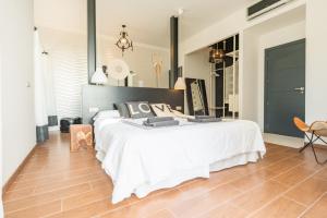 a bedroom with a large white bed and a wooden floor at Nyumba ya Sun in Cala Tarida