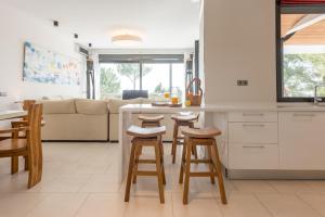 a kitchen and living room with a counter and stools at Nyumba ya Sun in Cala Tarida