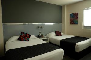 a hotel room with two beds and a window at Homesuites Rotarismo in Culiacán