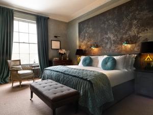 a bedroom with a king sized bed and a chair at No131 The Promenade in Cheltenham
